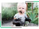 Mikrobiota - tajny sojusznik czy ukryty wróg? Dziecko ubrudzone błotem siedzące w ogrodzie