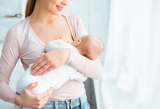 Młoda mama karmiąca piersią niemowlę w domu Młoda mama karmiąca piersią niemowlę w domu
