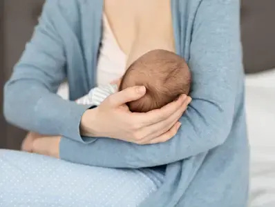 Laktacja po cesarskim cięciu – jak naturalnie wspierać karmienie piersią? dziecko karmione piersią na rękach mamy